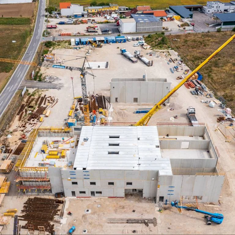 Luftaufnahme einer großen Baustelle mit Kranen, Hallenbau und Gewerbeflächen